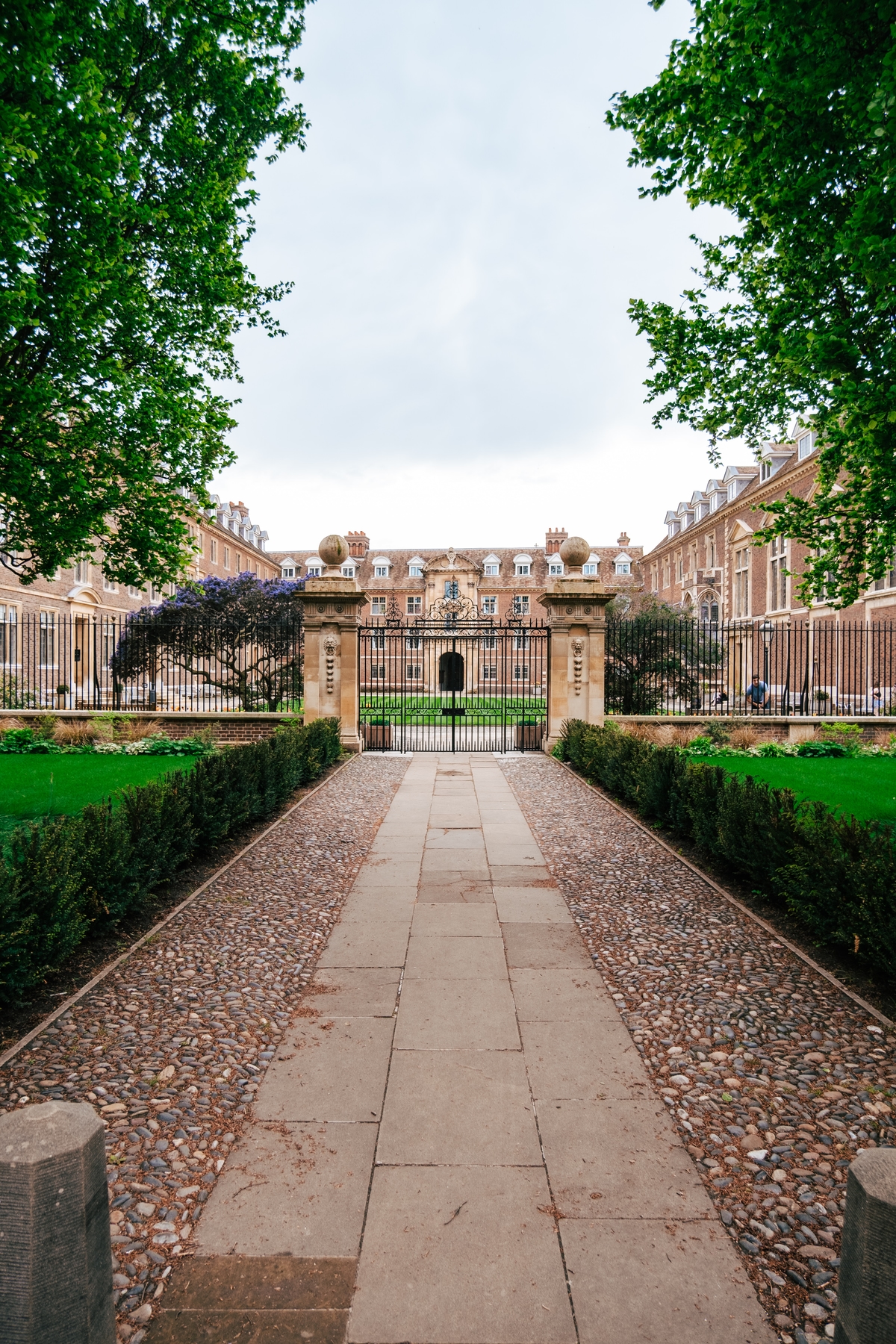 A walkway leading to a large building with a gate